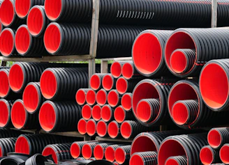 a pile of red and black pipes stacked on top of each other