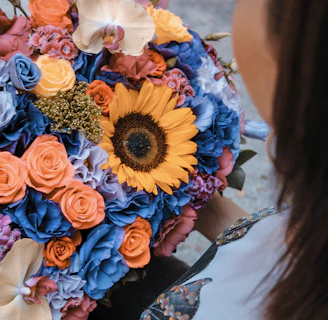A large, vibrant bouquet of roses being presented to a delighted recipient outdoors.