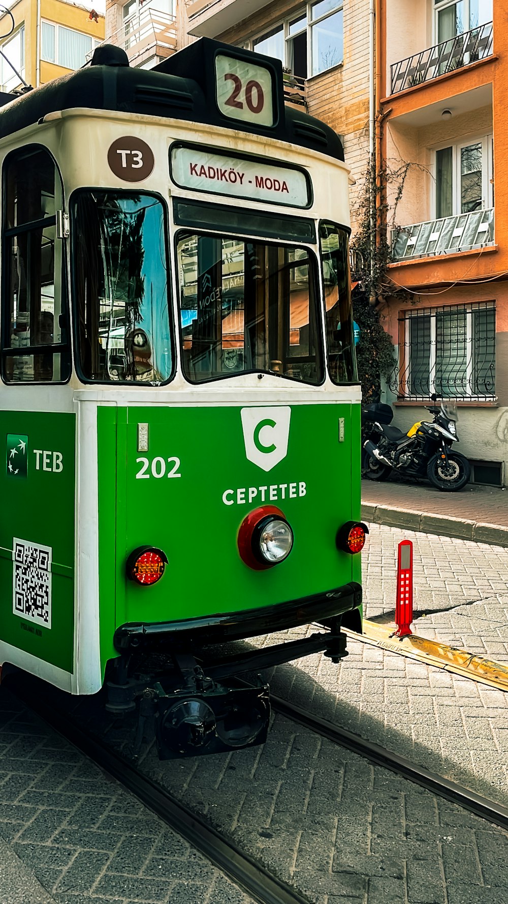 a green and white trolley on a city street