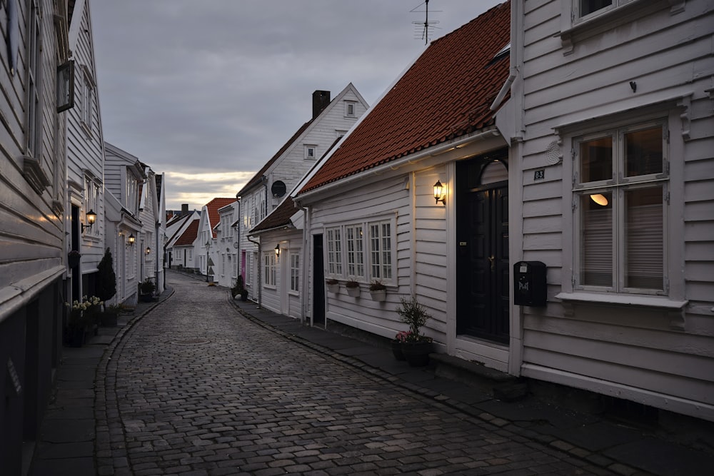 a cobblestone street lined with white houses