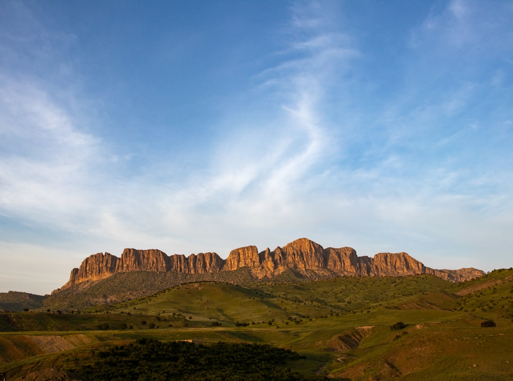 a mountain range with a few clouds in the sky