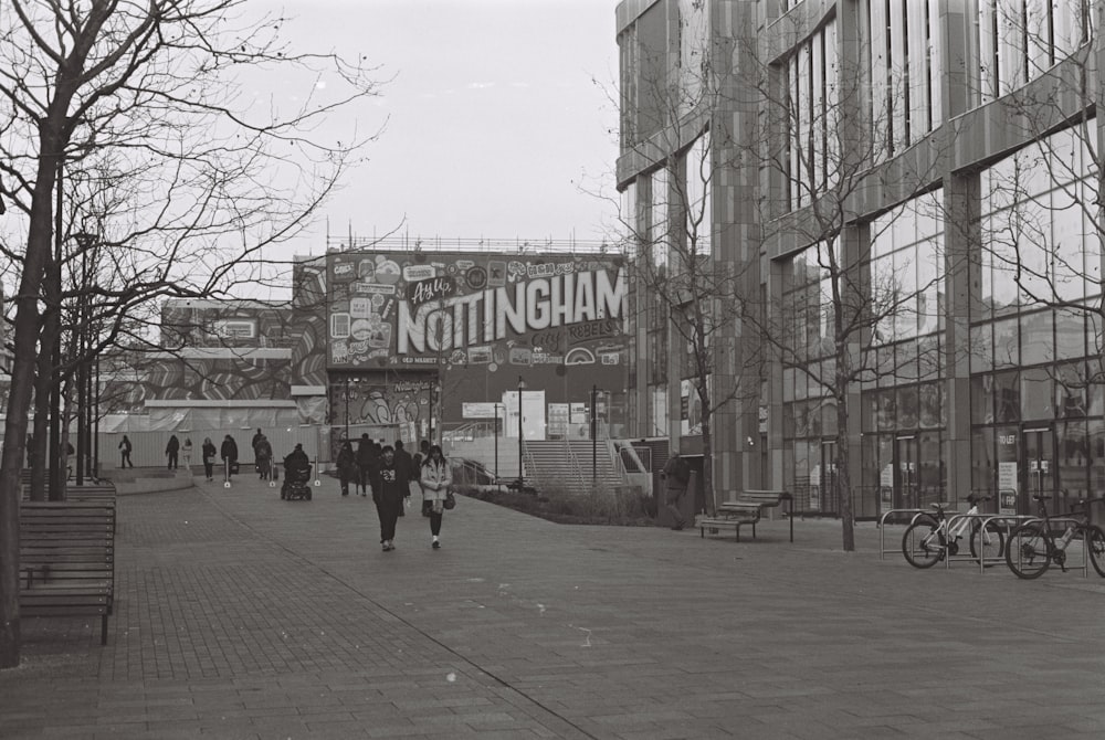 a black and white photo of people walking down a street