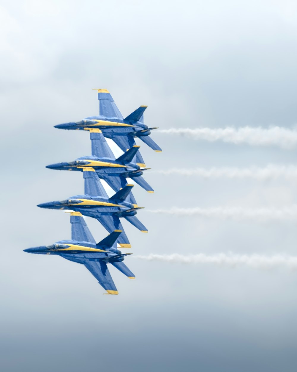 a group of fighter jets flying through a cloudy sky