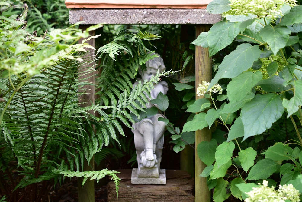 eine Statue einer Frau inmitten eines Gartens