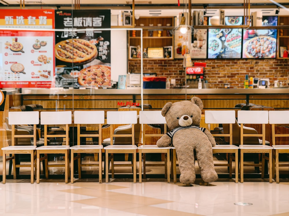 a teddy bear sitting on a table in a restaurant