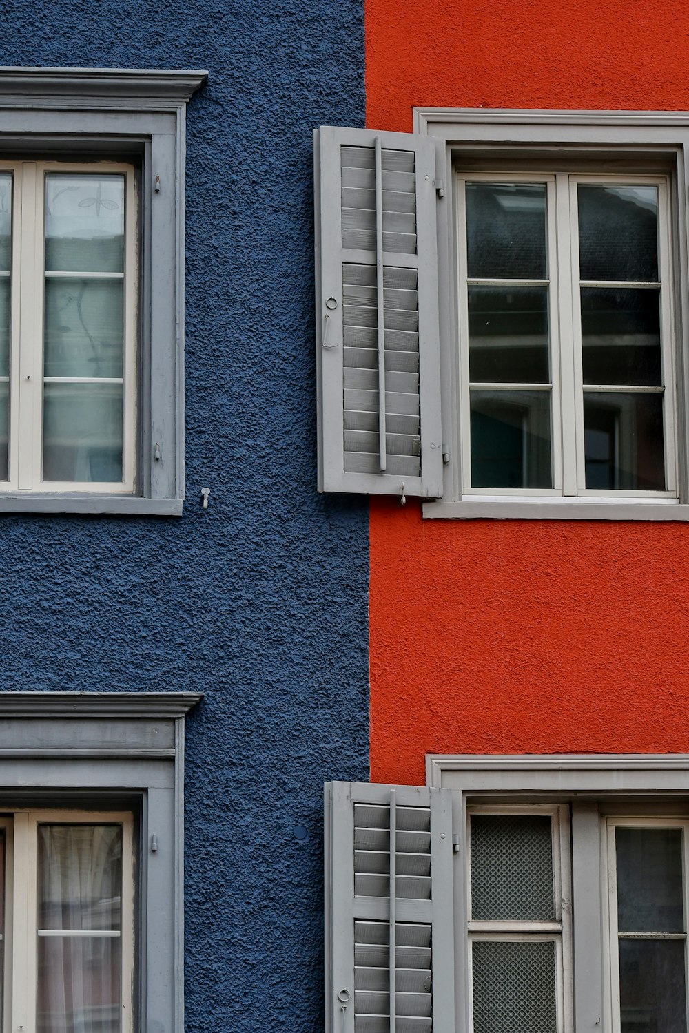 a red and blue building with two windows