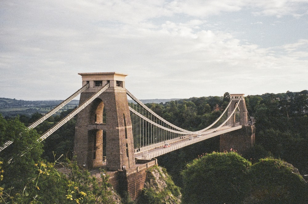 a tall bridge spanning over a lush green hillside