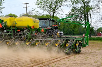 Close-up of a planter machine part with green fields in the background