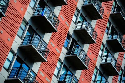 Facade of a contemporary apartment building with rust-colored panels and large balconies.