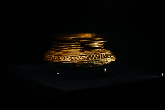 Close-up of a handcrafted brass decorative bowl with intricate Indian motifs glowing under warm light