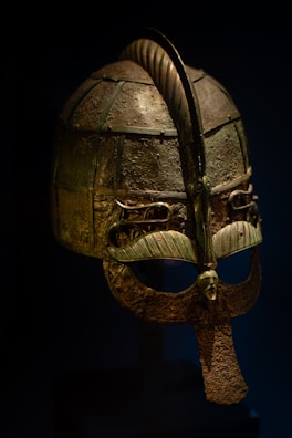 A carefully crafted replica of an ancient Roman helmet resting on a dark velvet cushion.