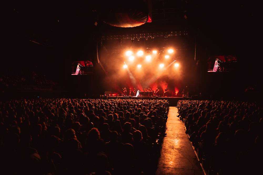 a crowd of people sitting in front of a stage