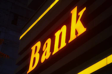 a bank sign lit up in the dark