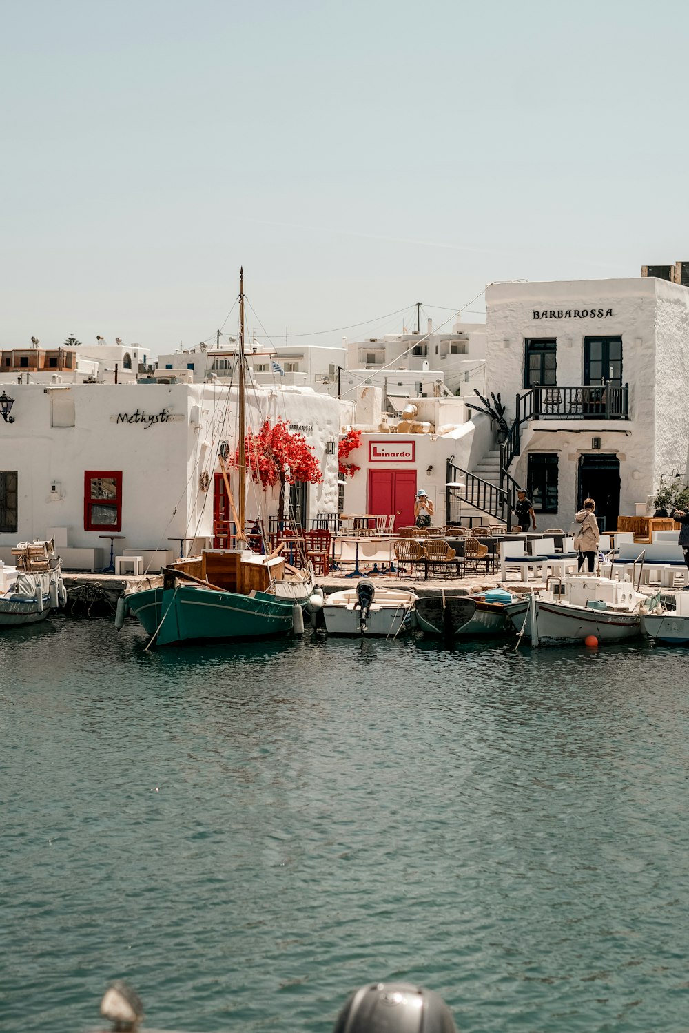 a group of boats sitting in a harbor next to a white building