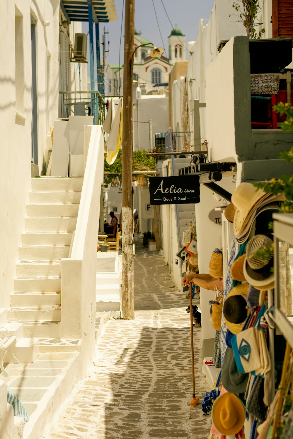 a narrow street with a bunch of hats hanging on the wall