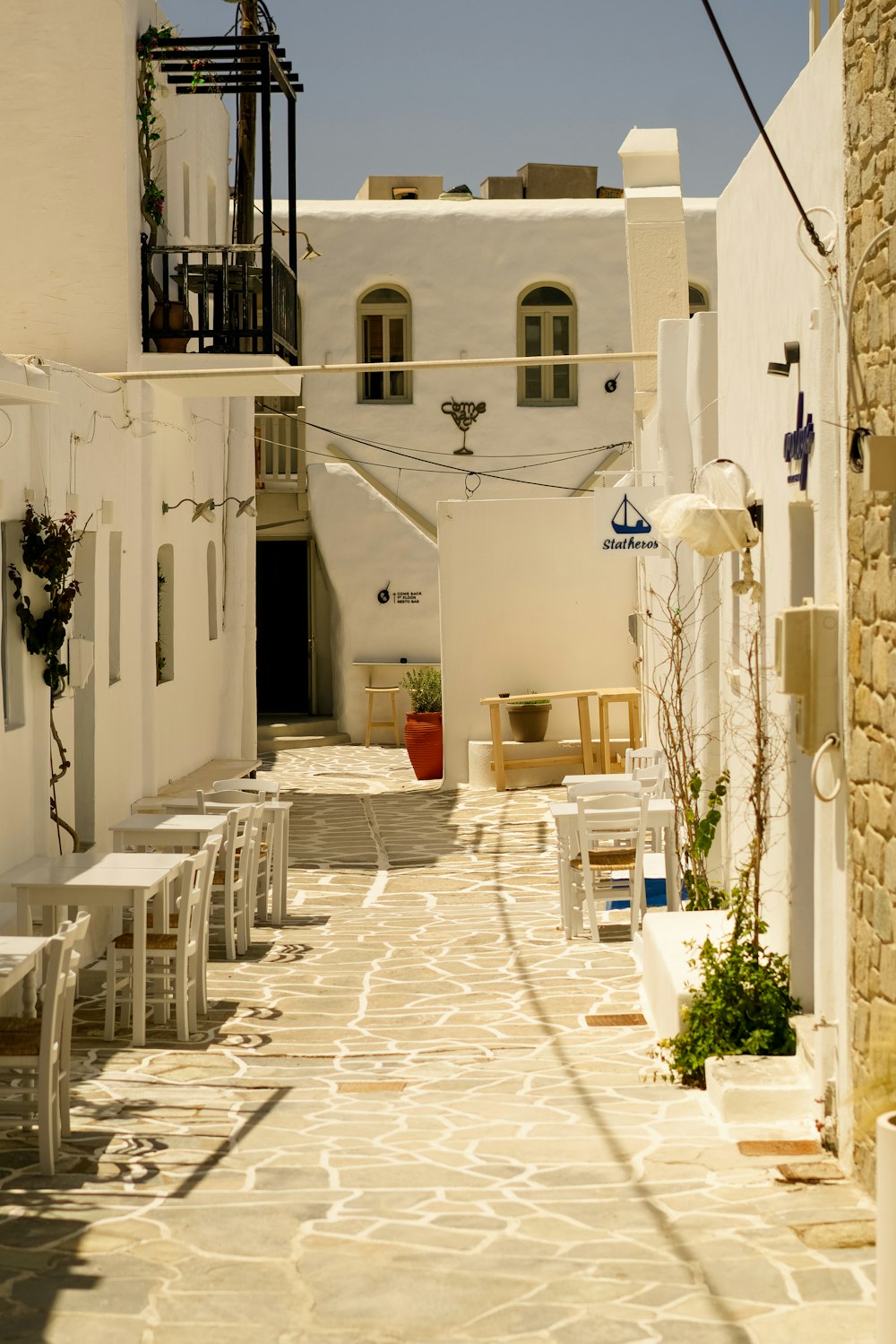 a narrow alley way with tables and chairs