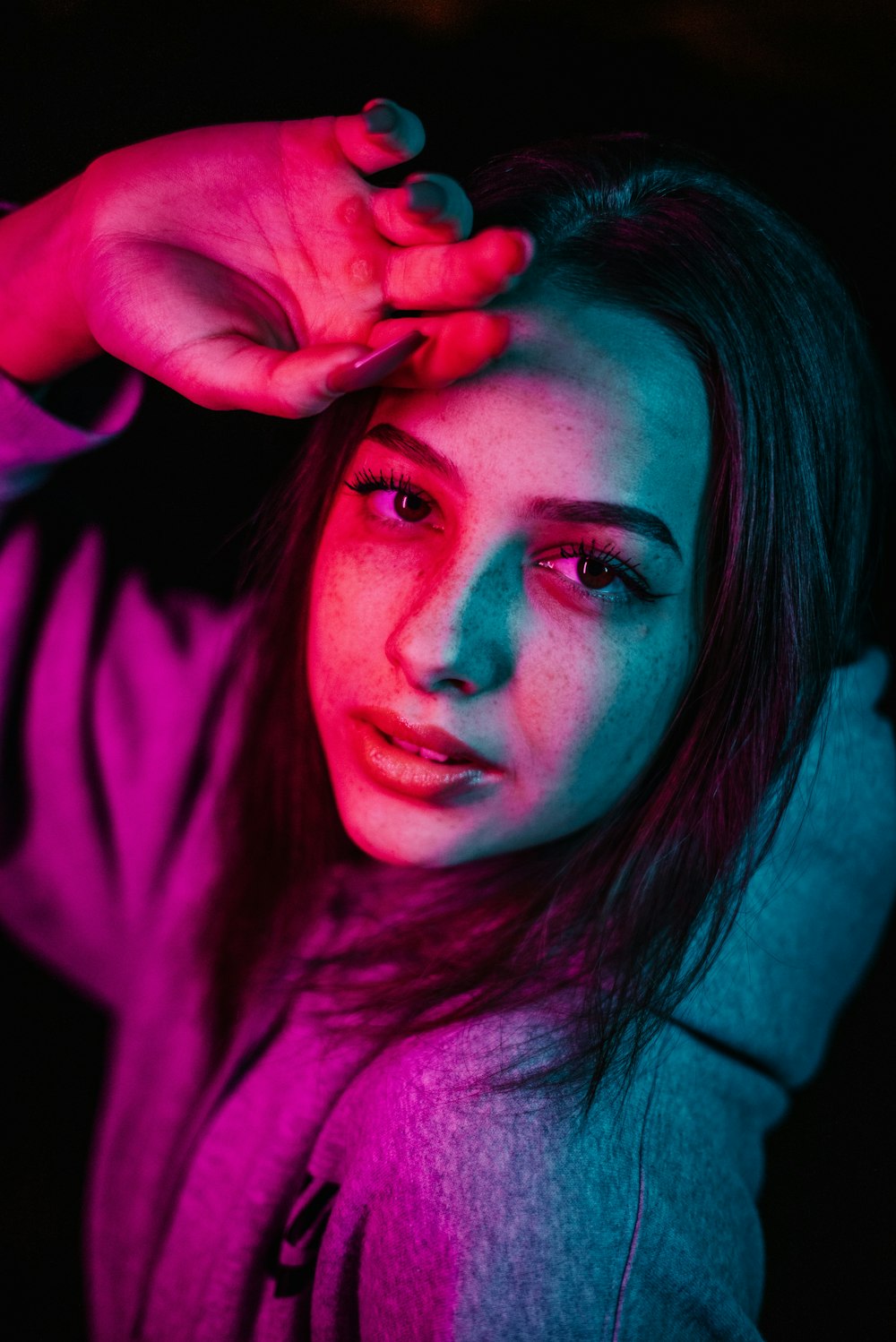 Eine junge Frau hält ihr Haar im Dunkeln