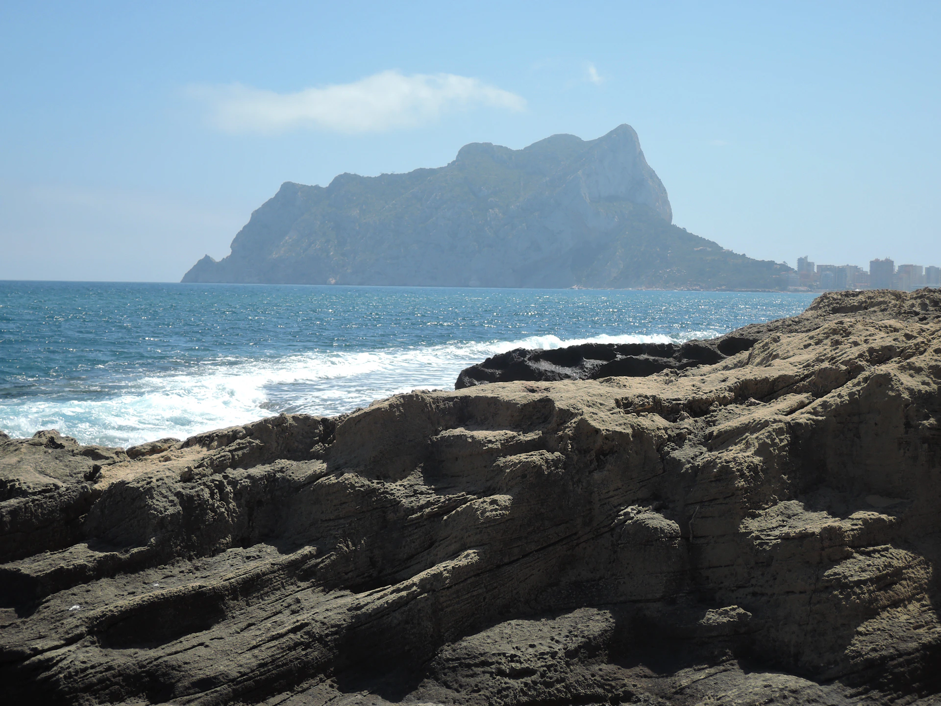 a rocky beach with a mountain in the background