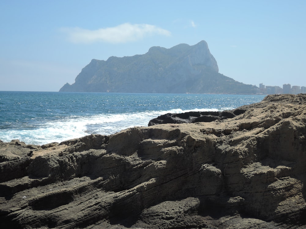 a rocky beach with a mountain in the background