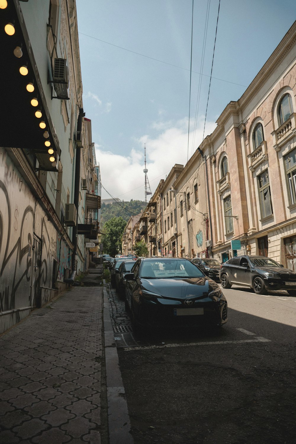 a car parked on the side of a street next to a building