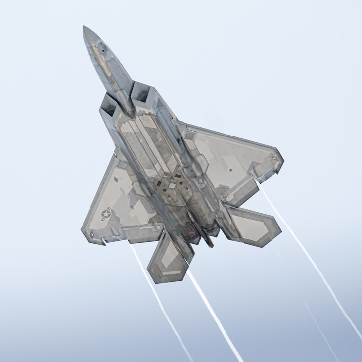a fighter jet flying through a blue sky