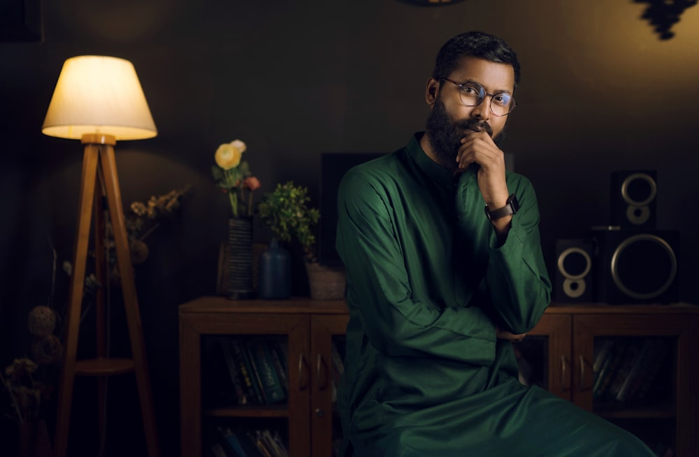 a man in a green outfit sitting on a table