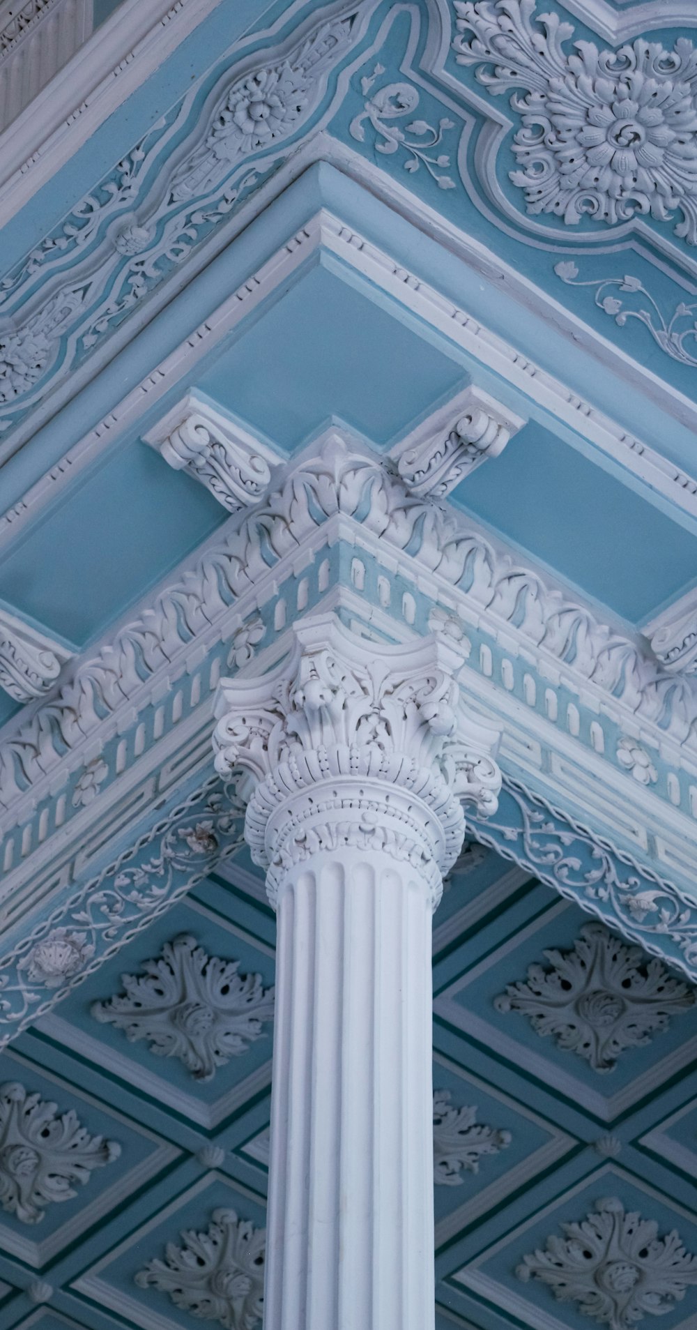 a close up of a white column with a blue ceiling
