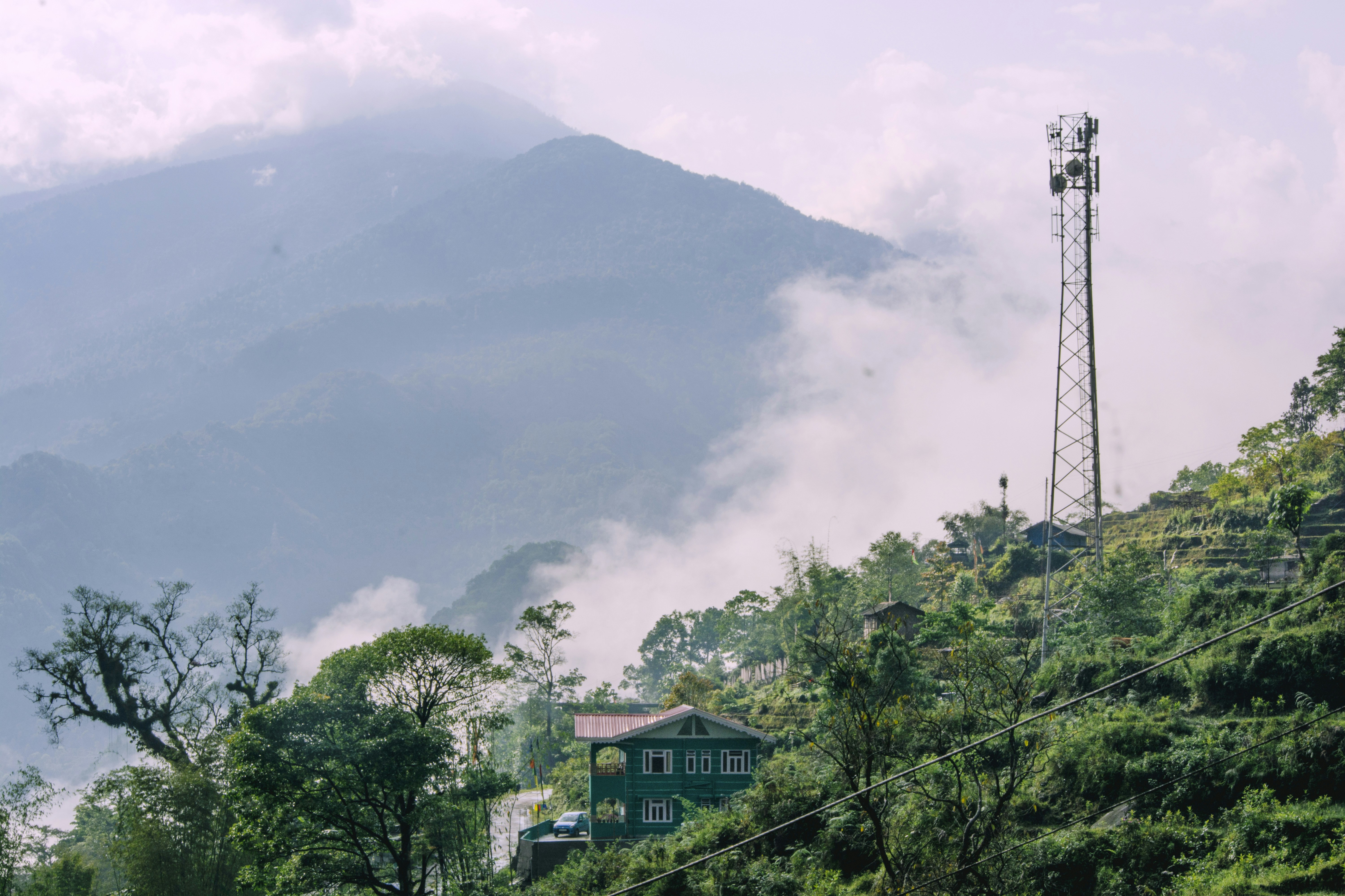 Una casa en una colina con una montaña al fondo