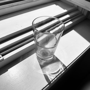 Clear glass of freshly filtered water with sunlight shining through.