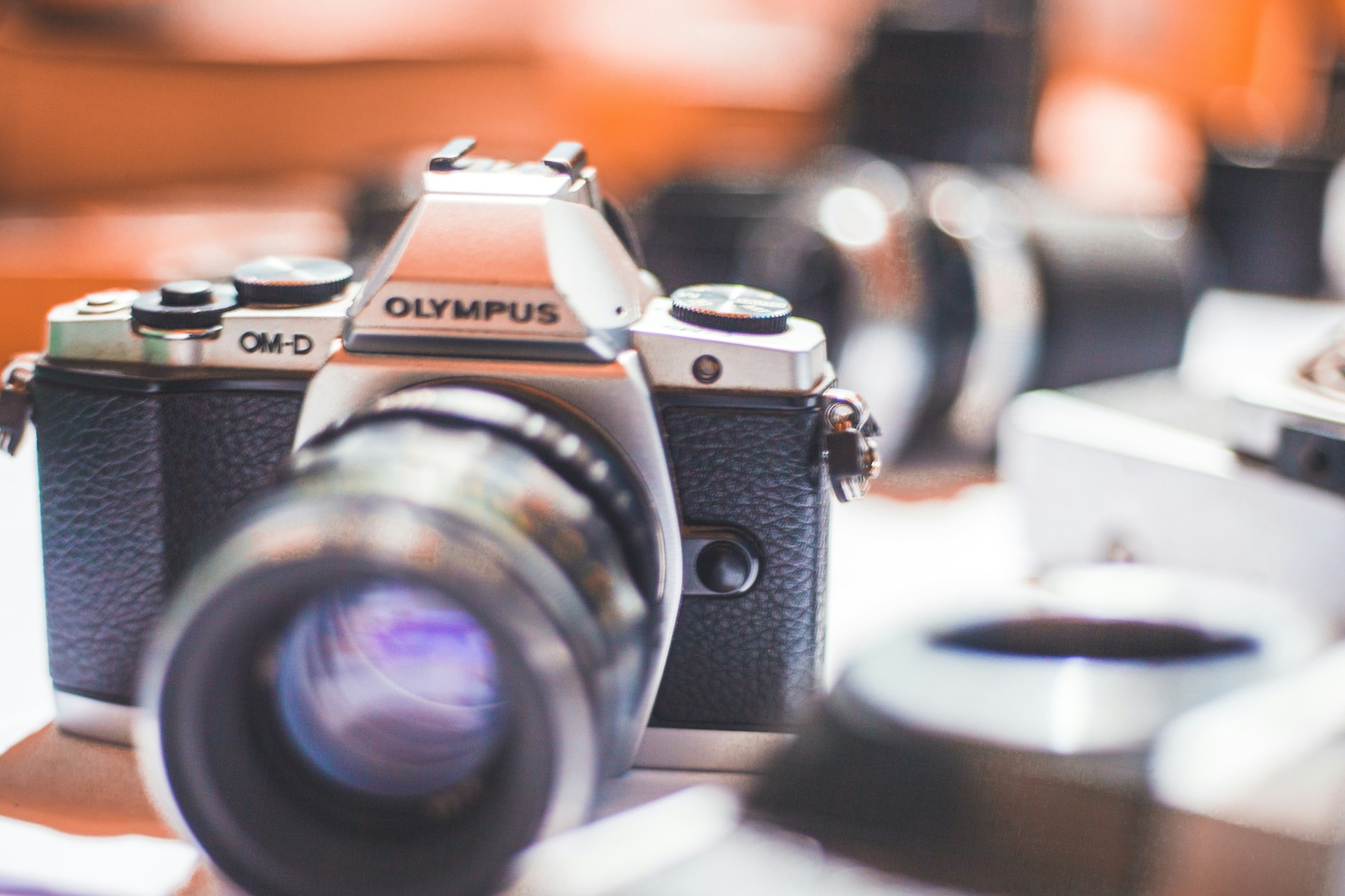 Close-up of a vintage film camera lens with soft focus on the background of a creative workspace.