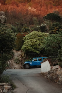 A robust green SUV parked near a scenic Italian countryside road.