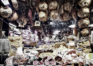 A rustic wooden counter displaying fresh cuts of meat, artisanal cheeses, and bottles of local wine inside a cozy Italian butcher shop.