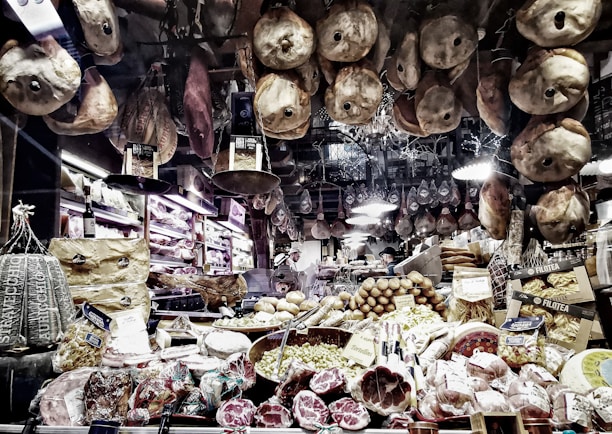An inviting shot of a gourmet deli counter featuring artisan cheeses, cured meats, and fresh bread.