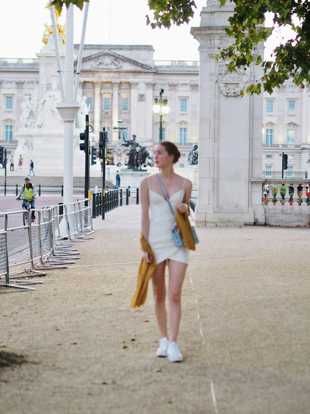 Eine Frau in einem weißen Kleid, die einen Bürgersteig entlanggeht