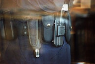 Close-up of a security badge and communication device on a uniform.