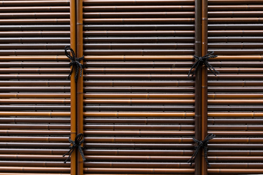 a close up of a bamboo fence with black bows