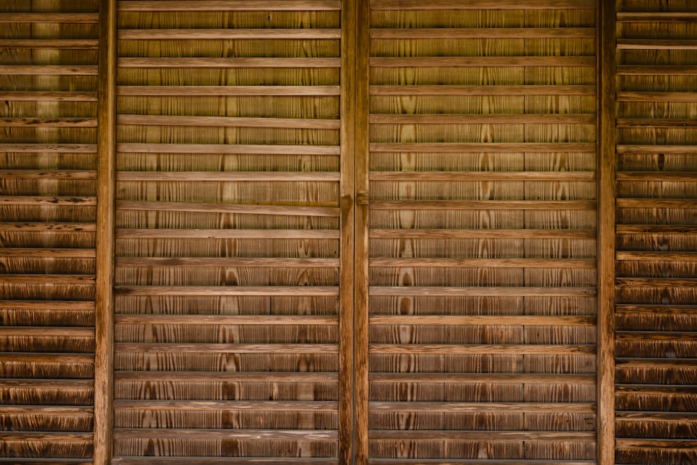 a wall made of wooden planks with a bench in front of it