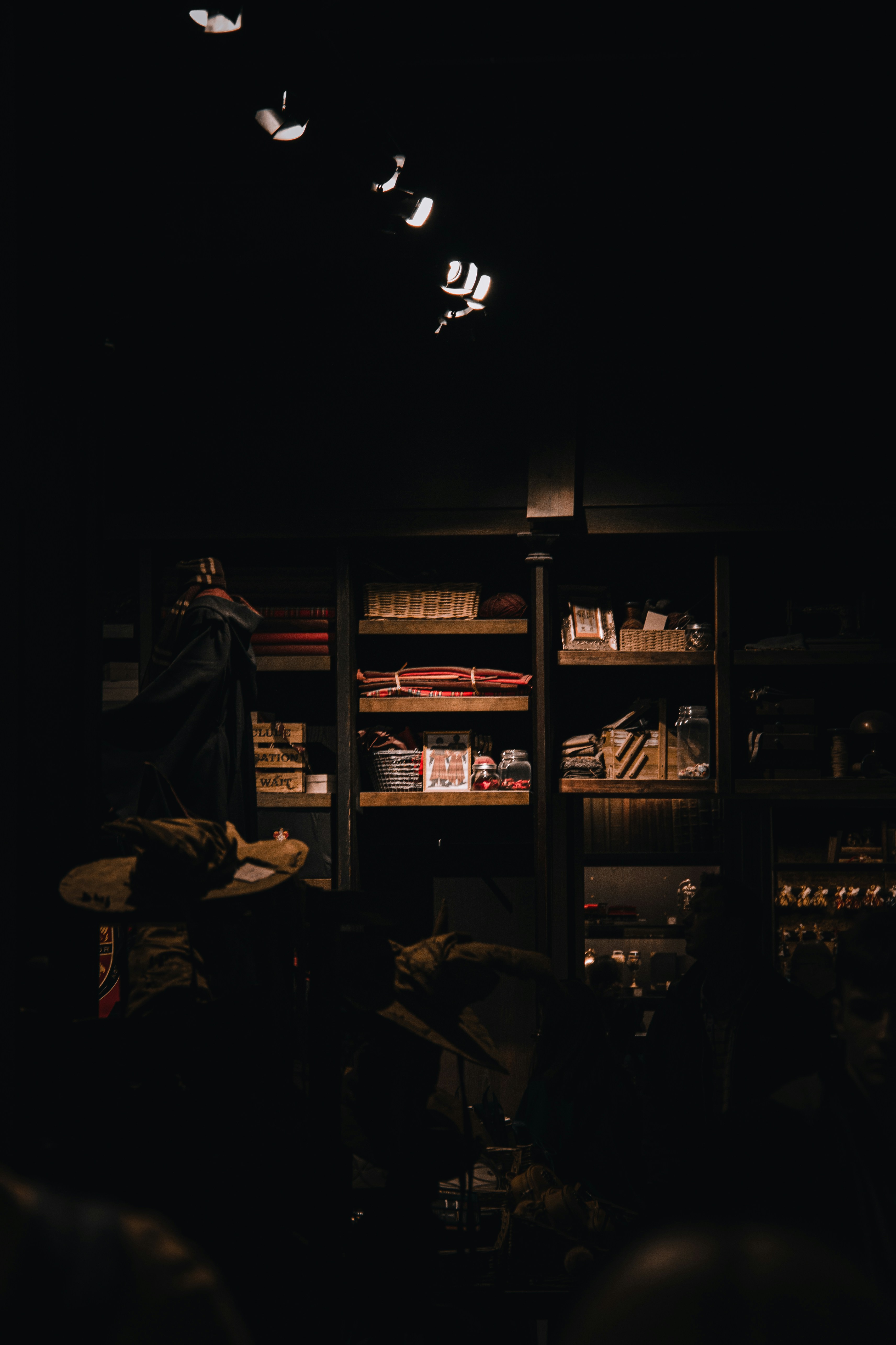 Dark product display with dramatic low-key lighting and deep shadows on merchandise