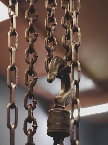 Close-up of heavy-duty chains and hooks used in machinery.
