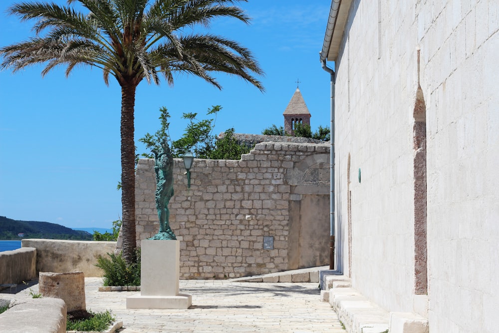 a stone building with a palm tree next to it