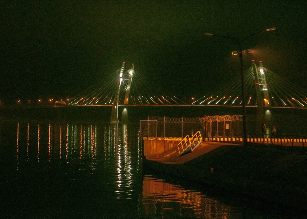 a bridge lit up at night over a body of water