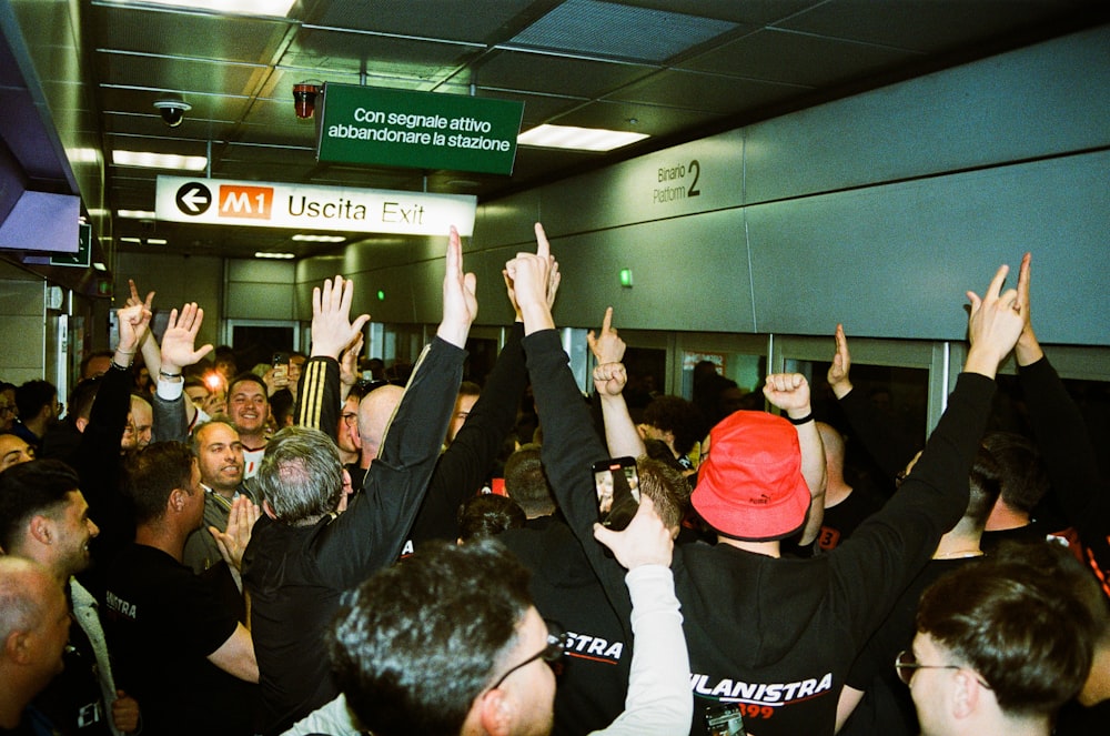 a group of people in a room with their hands in the air