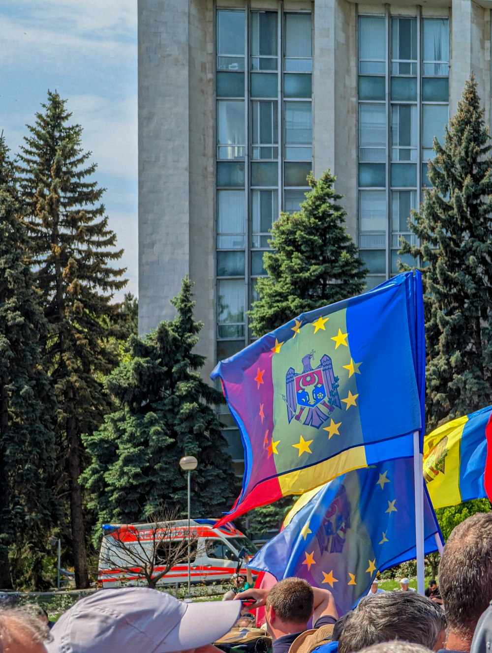a group of people holding flags in front of a building