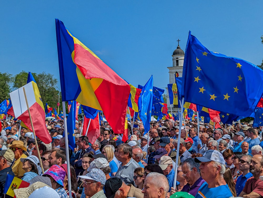 a large group of people holding flags in front of a building