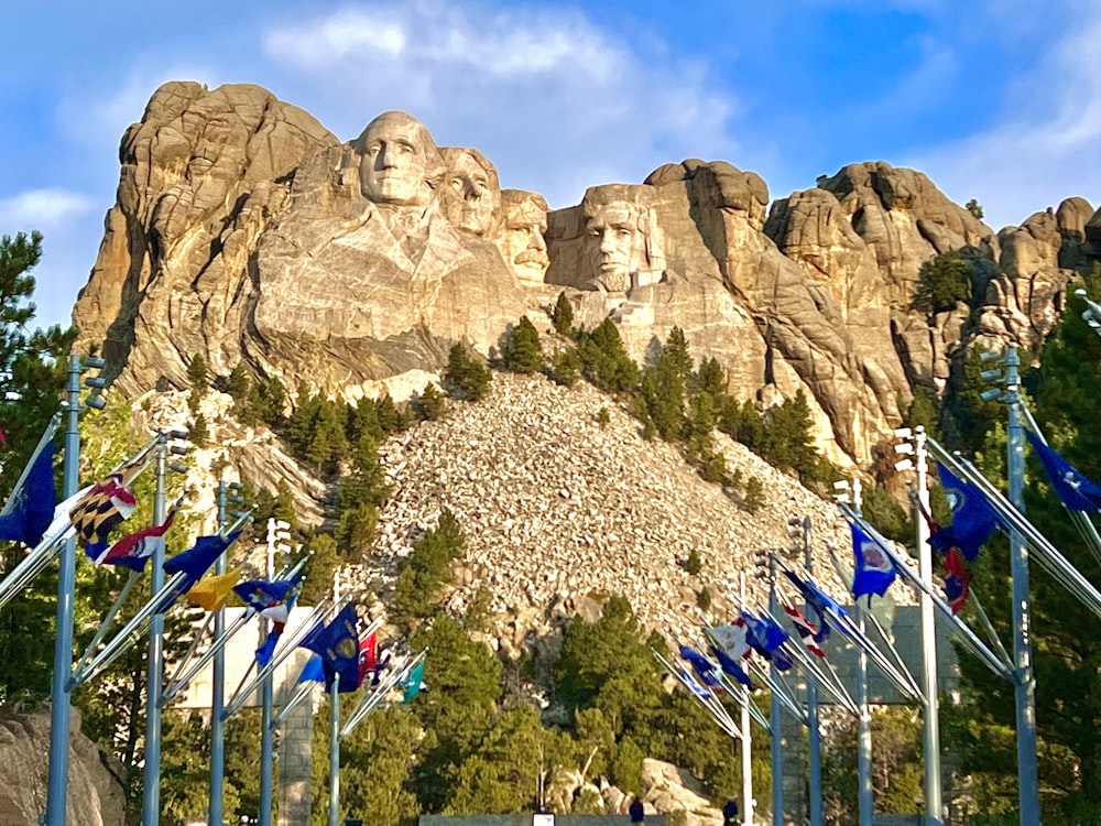a group of flags flying in front of a mountain