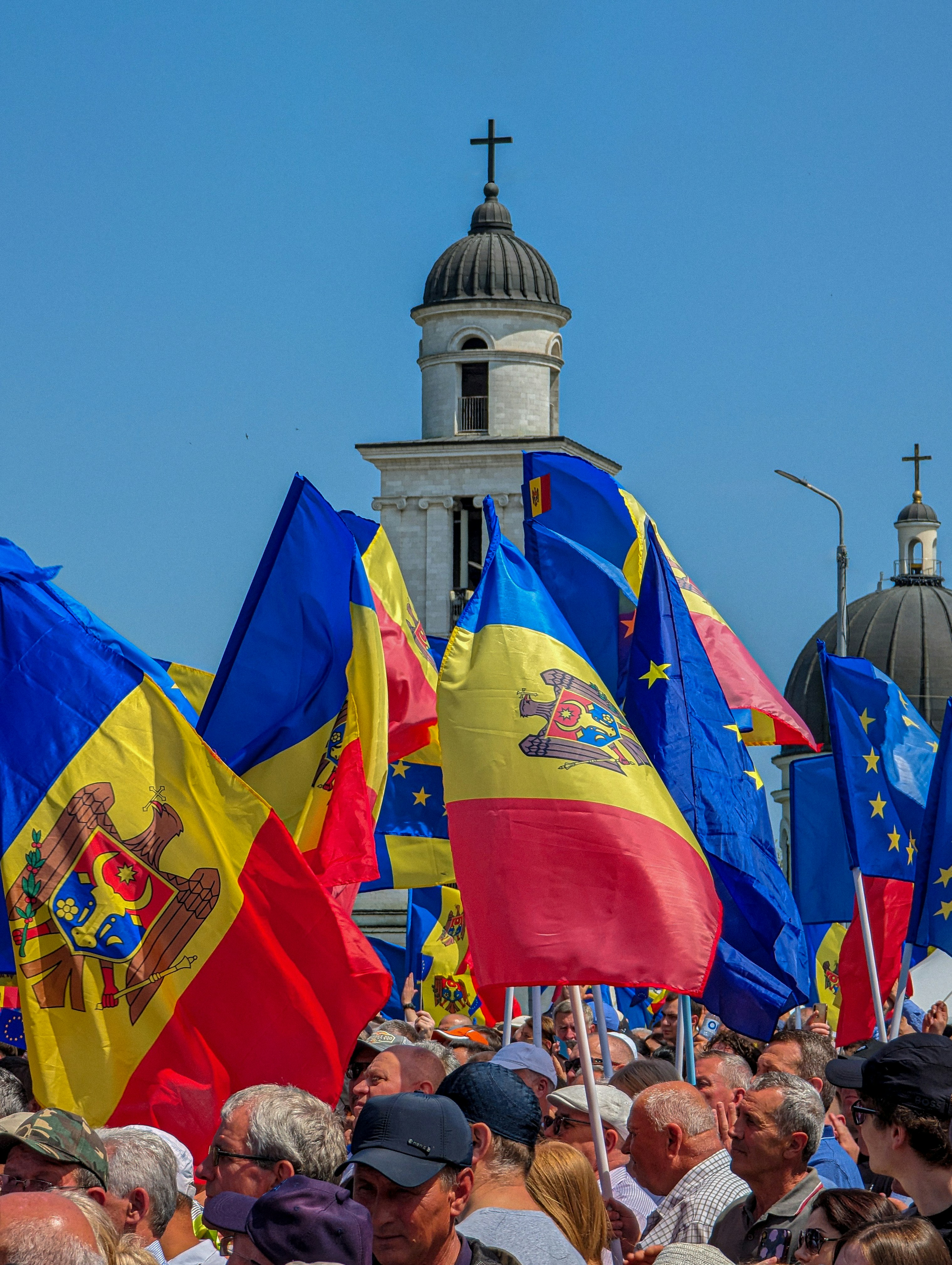 a crowd of people holding flags in front of a building -  Moldova Europeana