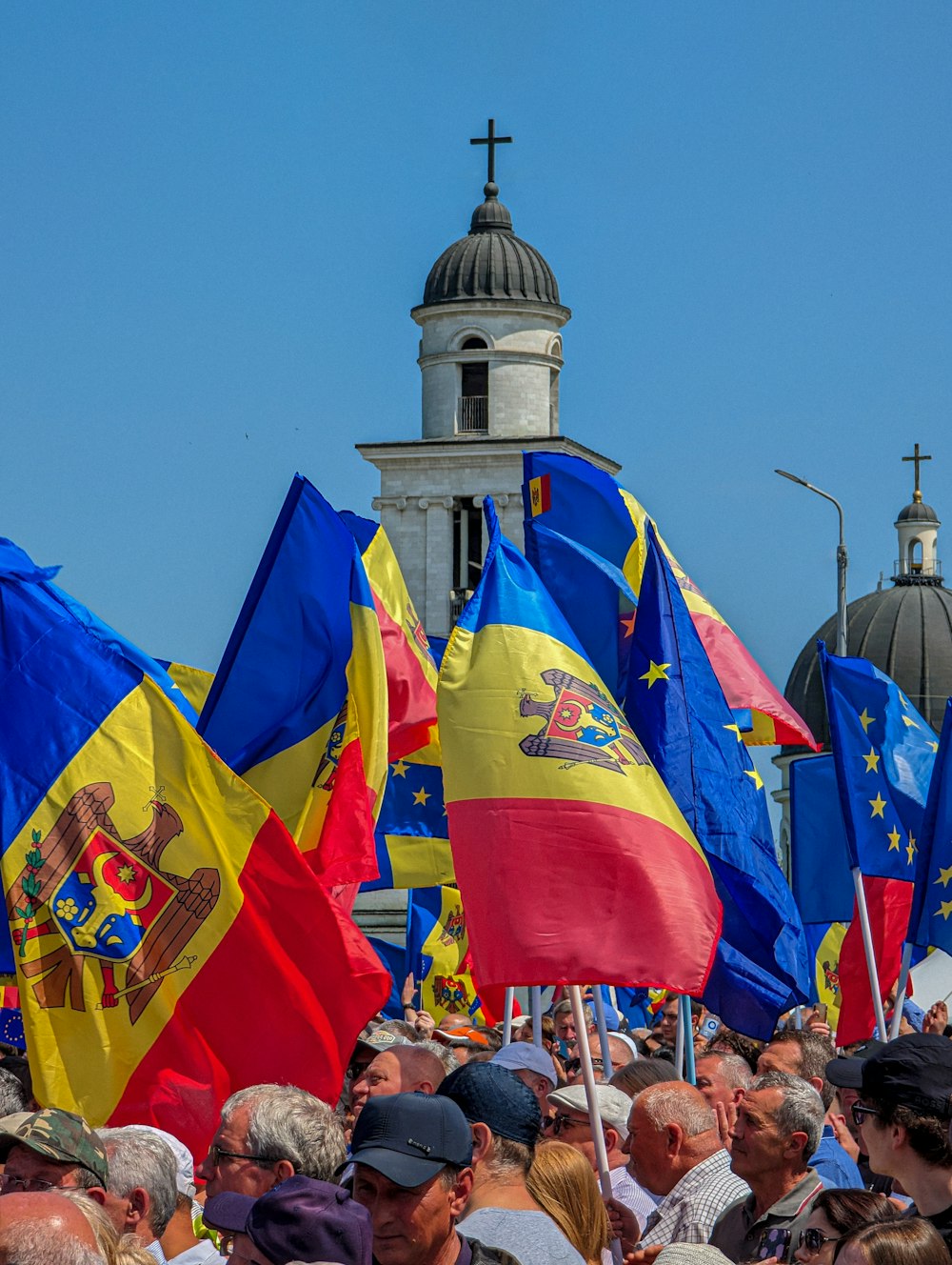 a crowd of people holding flags in front of a building