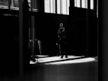 A dramatic stage scene with two actors locked in an intense dialogue under moody lighting.