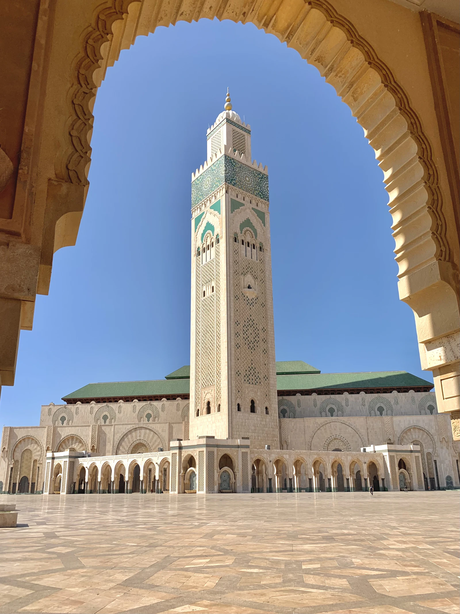 The minaret of Hassan II Mosque in Casablanca rises above carved arches.