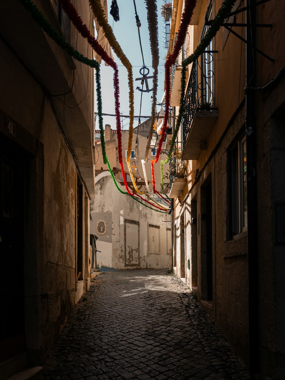 um beco estreito com decorações penduradas no teto